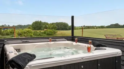 a jacuzzi tub with a view of a field at Villavilla 546 - Hostrup Strand, Limfjorden in Spottrup