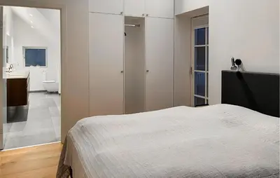 a bedroom with a bed and a bathroom at Amazing Apartment In Blokhus With House A Panoramic View in Blokhus
