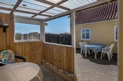 a patio with a table and chairs and a window at 730-Thyboron-Manovej-9 in Thyborøn