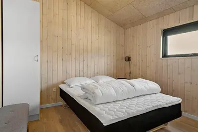 a bedroom with a bed in a wooden wall at BL1150-Saltum-Tolhoj-46 in Saltum