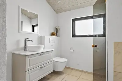 a bathroom with a sink and a toilet and a mirror at BL1150-Saltum-Tolhoj-46 in Saltum
