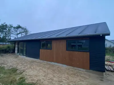 a small blue building with a black roof at BL1149-Blokhus-Paa-Bakken-12 in Blokhus