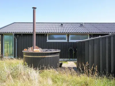 a black house with a black fence in front of it at 5 star holiday home in Saltum in Saltum