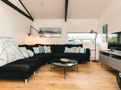 a living room with a black couch and a table at 5 star holiday home in Saltum in Saltum