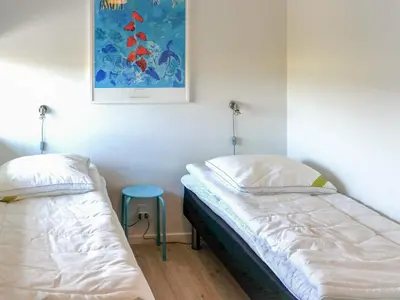 a bedroom with two beds and a blue stool at 5 star holiday home in Saltum in Saltum