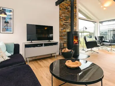 a living room with a fireplace and a tv at 5 star holiday home in Saltum in Saltum