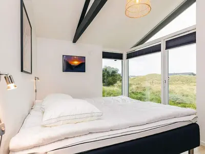 a bedroom with a bed with a large window at 5 star holiday home in Saltum in Saltum