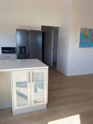 a kitchen with a white counter and a refrigerator at Luxury cottage close to the beach in Løkken