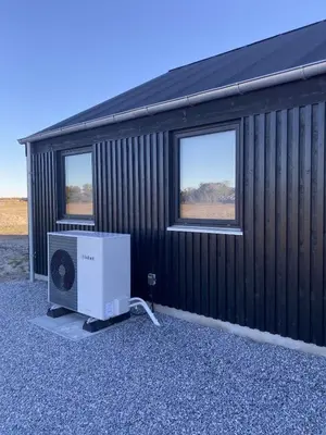 a building with a television and two windows at Luxury cottage close to the beach in Løkken