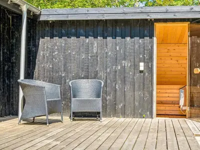 two chairs sitting on a deck next to a fence at 6 person holiday home in Roslev in Roslev