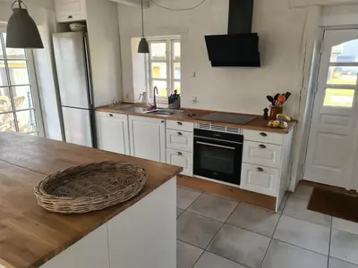 a kitchen with white cabinets and a counter top at Strandhuset in Agger