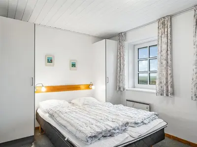 a bedroom with a bed and a window at Holiday Home Siljana - 200m from the sea by Interhome in Lemvig
