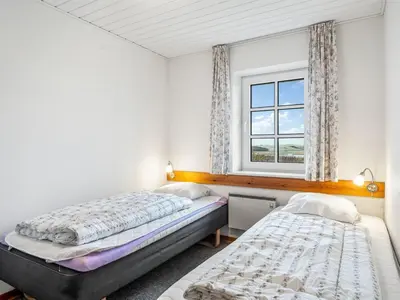 two beds in a room with a window at Holiday Home Siljana - 200m from the sea by Interhome in Lemvig
