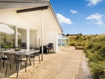 a patio with a table and chairs next to a building at Holiday Home Nimrod - 70m from the sea by Interhome in Thisted