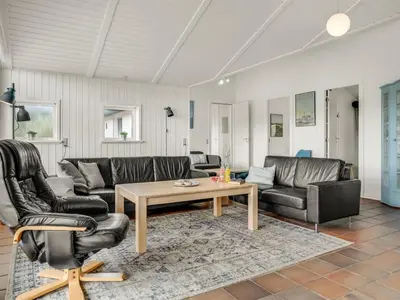 a living room with leather furniture and a coffee table at Holiday Home Nimrod - 70m from the sea by Interhome in Thisted