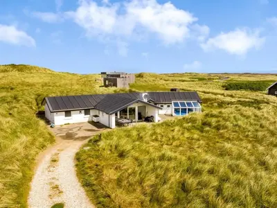 a house in the middle of a grassy field at Holiday Home Nimrod - 70m from the sea by Interhome in Thisted