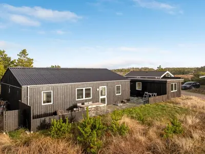 a tiny house with a black roof at Holiday Home Ovine - 900m from the sea by Interhome in Thisted