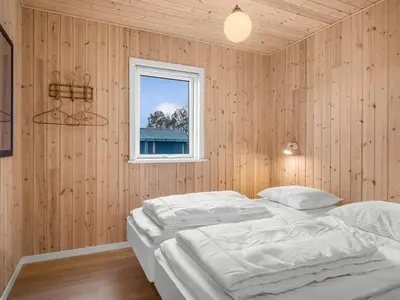 a bedroom with a white bed and a window at Holiday Home Ovine - 900m from the sea by Interhome in Thisted