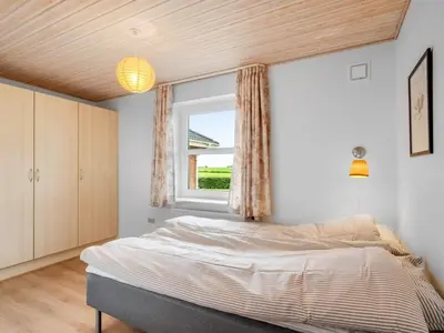 a bedroom with a bed and a window at Holiday Home Erja - 300m to the fjord by Interhome in Roslev
