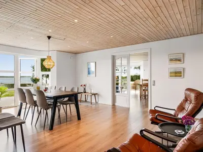 a dining room and living room with a table and chairs at Holiday Home Erja - 300m to the fjord by Interhome in Roslev