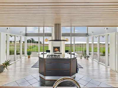 an open kitchen with a stove and a fireplace at Holiday Home Fridhild - 150m to the fjord by Interhome in Redsted