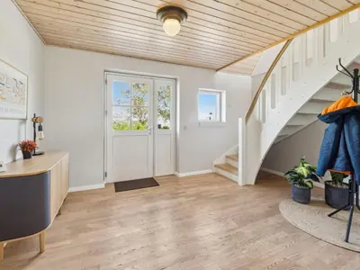 an empty room with a staircase and a white door at Holiday Home Fridhild - 150m to the fjord by Interhome in Redsted