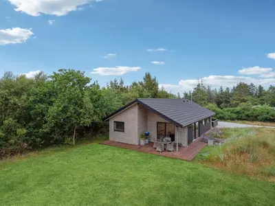 a small house with a deck in a yard at Holiday Home Muriel - 1-6km from the sea by Interhome in Blokhus