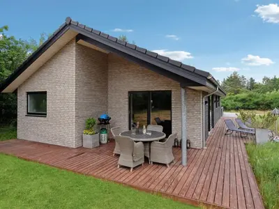 a patio with a table and chairs on a deck at Holiday Home Muriel - 1-6km from the sea by Interhome in Blokhus