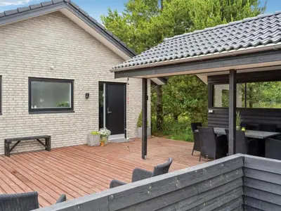 a patio with chairs and a wooden deck at Holiday Home Muriel - 1-6km from the sea by Interhome in Blokhus