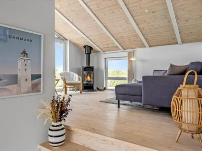 a living room with a blue couch and a fireplace at Holiday Home Osfrid - 175m from the sea by Interhome in Blokhus