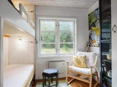 a small room with a chair and a window at Holiday Home Patti - 700m from the sea by Interhome in Blokhus