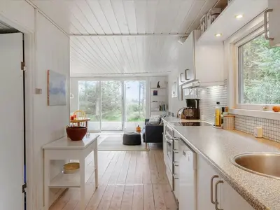 a kitchen with a sink and a large window at Holiday Home Patti - 700m from the sea by Interhome in Blokhus