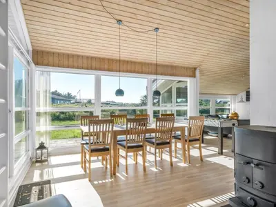 a dining room with a table and chairs at Holiday Home Peder - 700m from the sea by Interhome in Løkken