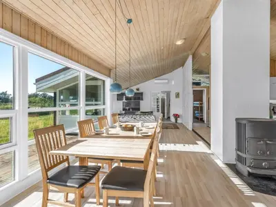 a kitchen and dining room with a table and chairs at Holiday Home Peder - 700m from the sea by Interhome in Løkken