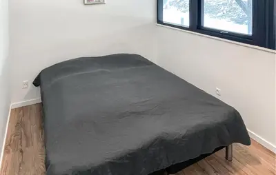a bed in a room with a black blanket at 3 Bedroom Stunning Home In Struer in Struer