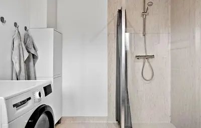 a bathroom with a shower and a washing machine at 2 Bedroom Cozy Home In Roslev in Roslev