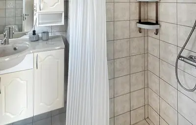 a bathroom with a shower curtain and a sink at 4 Bedroom Beautiful Home In Farsø in Farsø