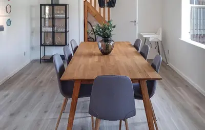 a dining room table with chairs and a vase on it at 4 Bedroom Beautiful Home In Farsø in Farsø