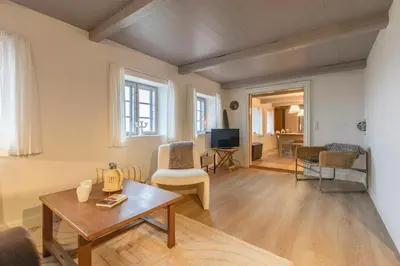 a living room with a table and chairs and a tv at Historic Ferry House By Limfjorden In Sillerslev in Øster Assels