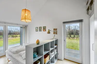 a bedroom with a bed and a desk and windows at JB374-Brovst-Kronvildtvej-222 in Tranum Strand