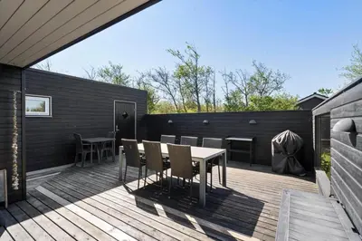 a patio with a table and chairs on a deck at JB374-Brovst-Kronvildtvej-222 in Tranum Strand