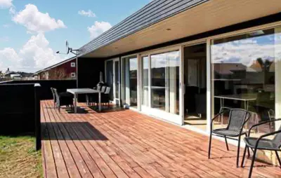 a deck with chairs and a table on a house at 3 Bedroom Amazing Home In Brovst in Brovst
