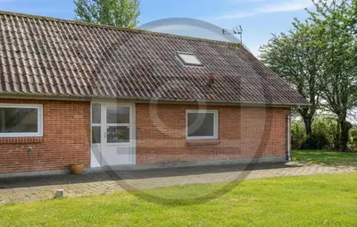 a red brick house with a white door at 2 Bedroom Pet Friendly Home In Øster Assels in Øster Assels