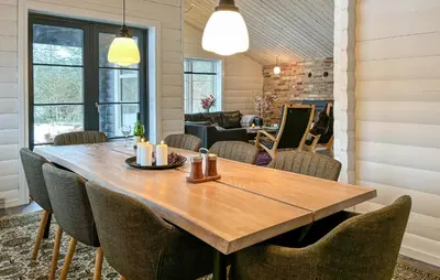 a dining room with a wooden table and chairs at Stunning Home In Løgstør With Sauna in Løgstør