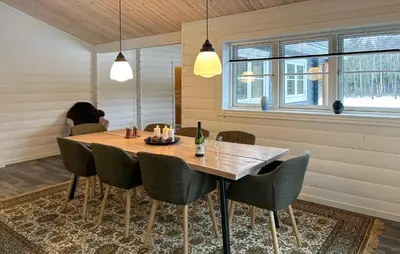 a dining room with a wooden table and chairs at Stunning Home In Løgstør With Sauna in Løgstør