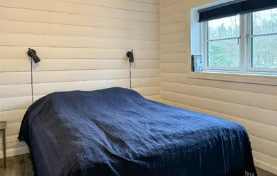 a bedroom with a blue blanket on a bed at Stunning Home In Løgstør With Sauna in Løgstør