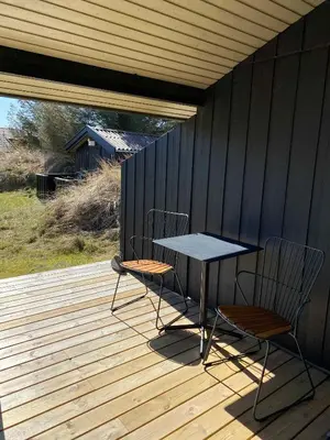 two chairs and a table on a wooden deck at Peaceful Base Near Beach And Nature in Saltum
