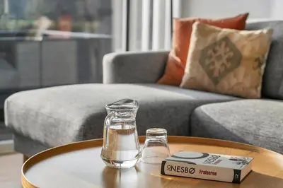 a glass bottle on a table next to a couch at JB405-Brovst-Kronvildtvej-37 in Tranum Strand