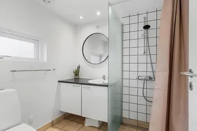 a white bathroom with a sink and a mirror at JB405-Brovst-Kronvildtvej-37 in Tranum Strand