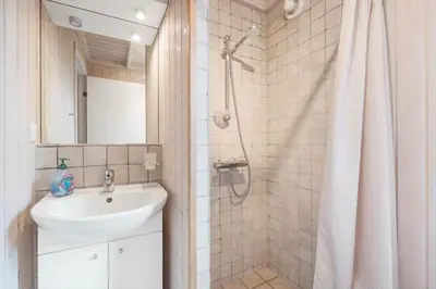 a bathroom with a sink and a shower with a shower curtain at BL1143-Blokhus-Engen-1 in Blokhus